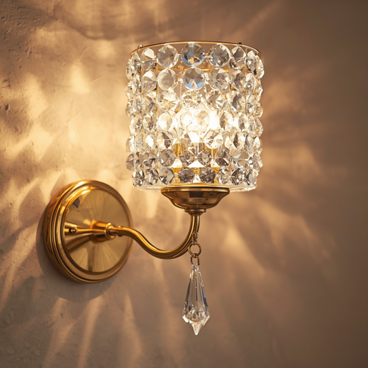 A gold crystal beaded wall sconce light with a dangling crystal pendant mounted on a textured wall casting sparkling light patterns.