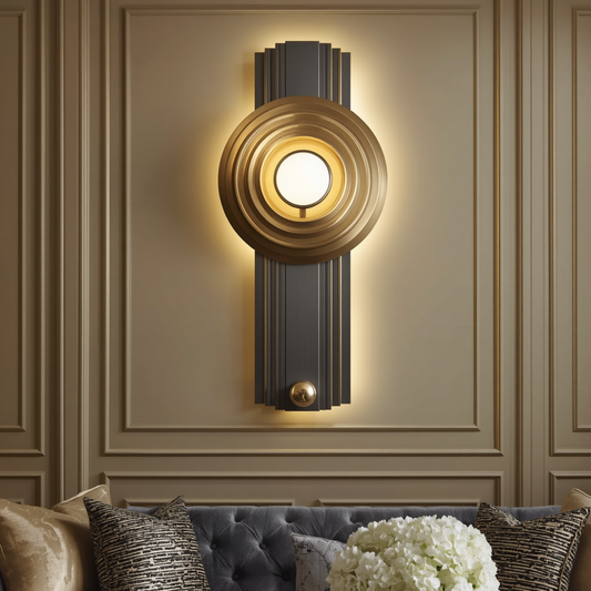 An art deco black and vertical gold geometric wall sconce with a central glowing globe mounted on a paneled wall above a tufted sofa.