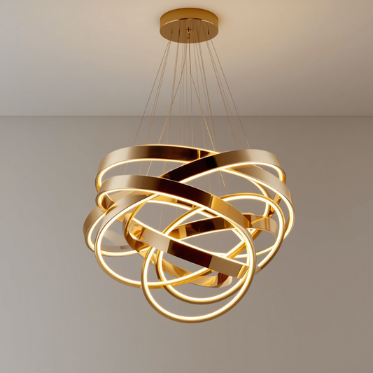 A modern gold interlocking rings LED chandelier hanging from a ceiling casting warm light across the fixture.