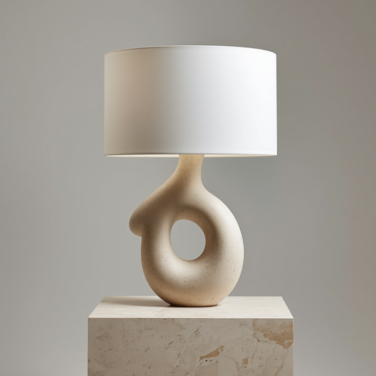 A natural terracotta base table lamp with a rattan shade placed on a wooden bedside table next to a small potted plant.